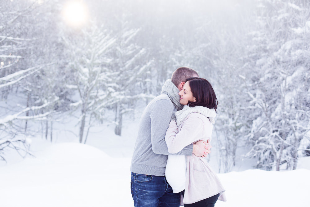 Photo de grossesse d'un couple à la montagne en hiver