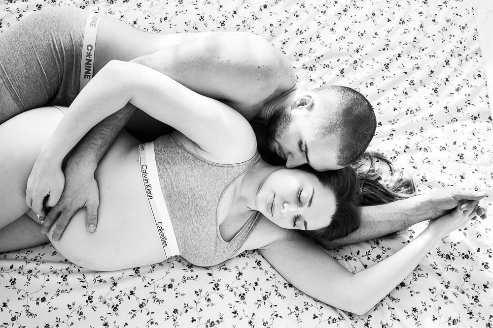 Shooting photo de grossesse d'un couple dans leur lit
